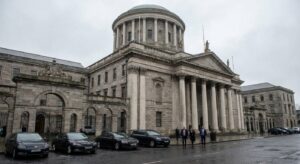 Stone façade of a high court building under gray sky, empty steps and formal architecture.