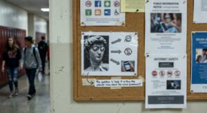 School corridor notice board with laminated online-safety advice sheets and a calm, institutional atmosphere.