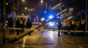 Nighttime scene of a cordoned-off telecom mast with emergency responders, documentary tone.