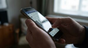 Hands taking a screenshot on a modern smartphone, displayed naturally on a table.